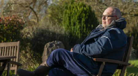 A older man sat on a park bench