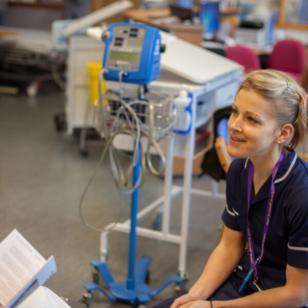 A nurse talking to someone in a hospital setting.