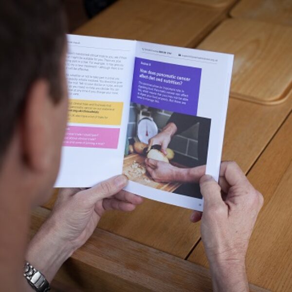 A man looking through a PCUK booklet