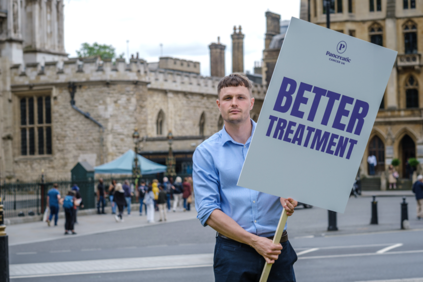 man holding a sign saying better treatment