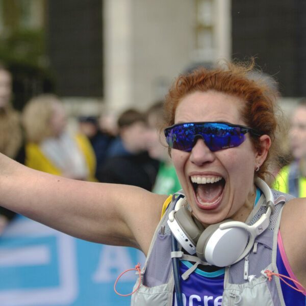 smiling woman running the london marathon fundraising for pancreatic cancer uk