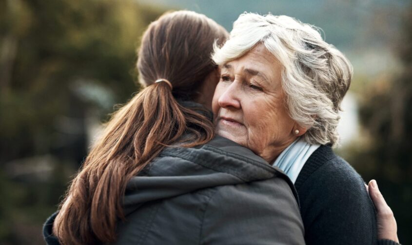 An older woman hugging a younger woman