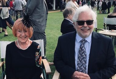 Man and woman dressed smartly sitting on chairs outside on a lawn