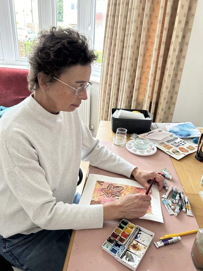 Woman sitting at desk painting