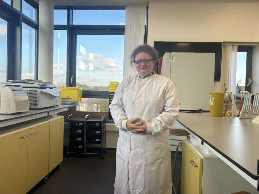 Kate Herbert standing in a lab wearing a white lab coat