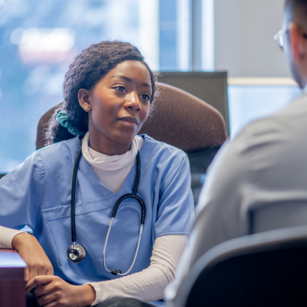 Doctor in scrubs listening to patient talk