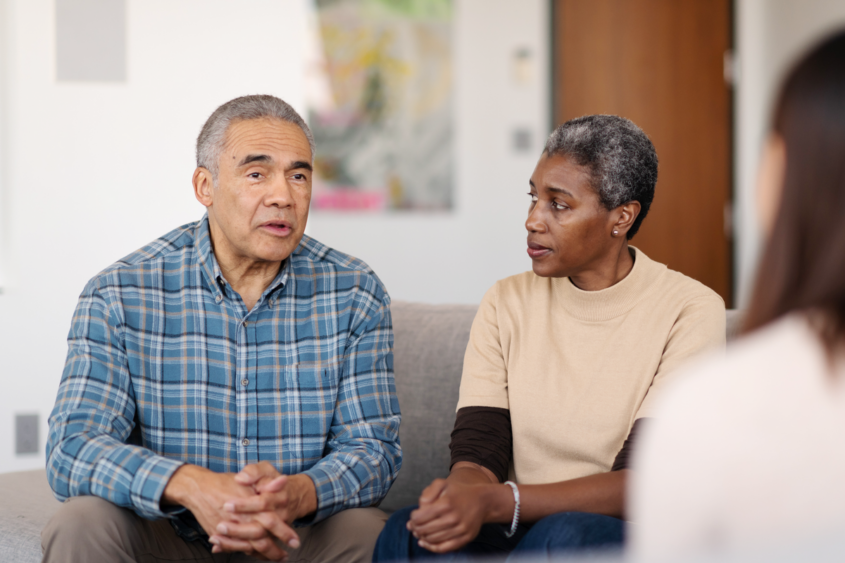 People sitting on a sofa talking to a health professional